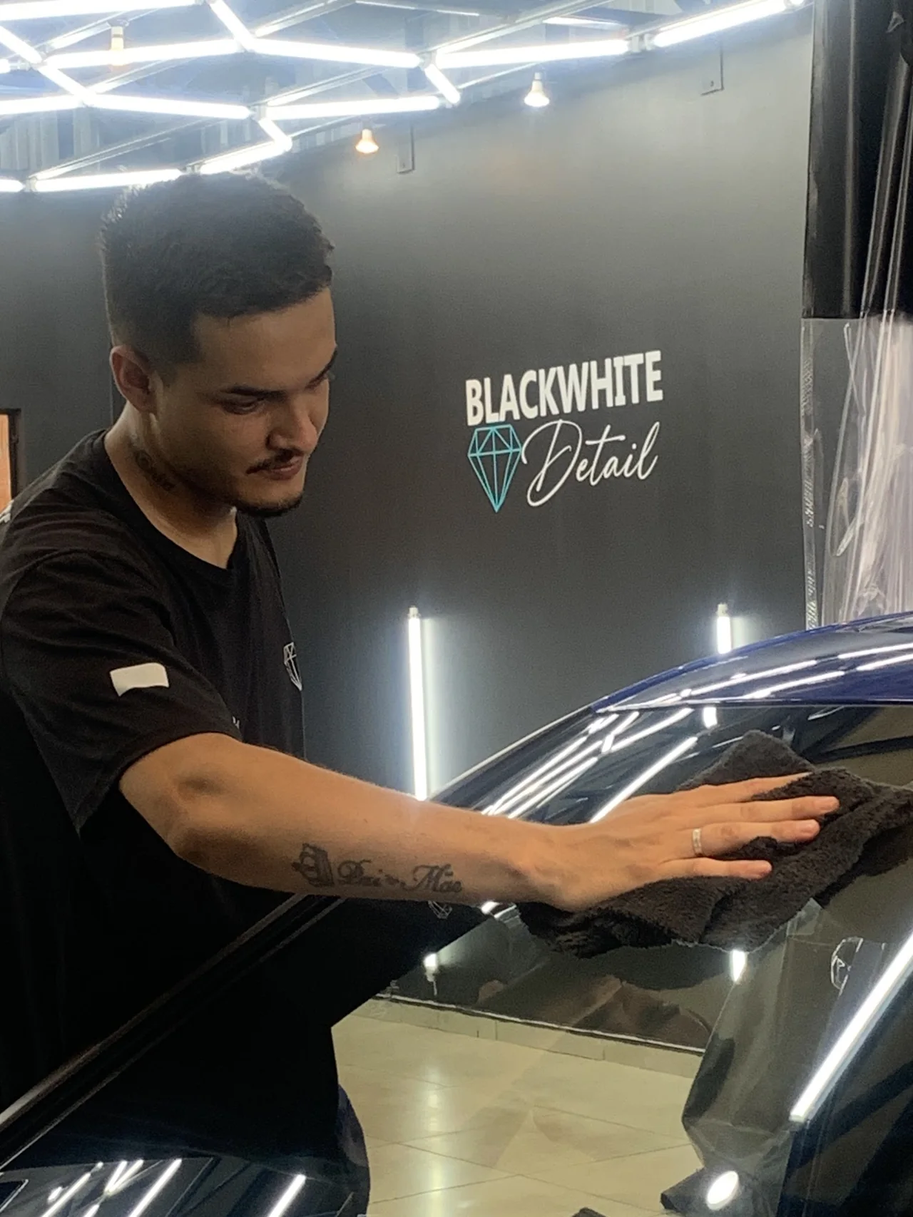 Profissional da Blackwhite trabalhando cuidadosamente na pintura azul de um veículo