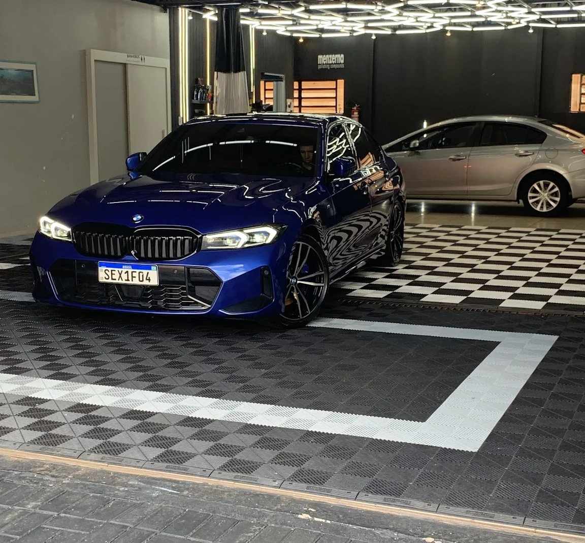 BMW azul na oficina Blackwhite Detail em Cascavel, sobre o piso quadriculado